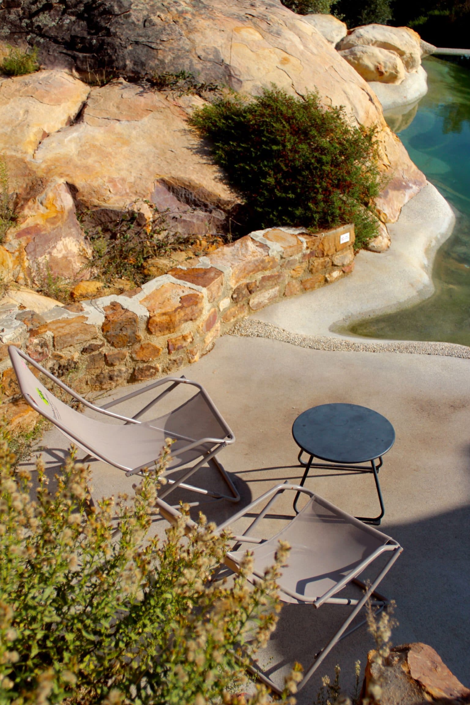 A poolside terrace nestled against natural rock